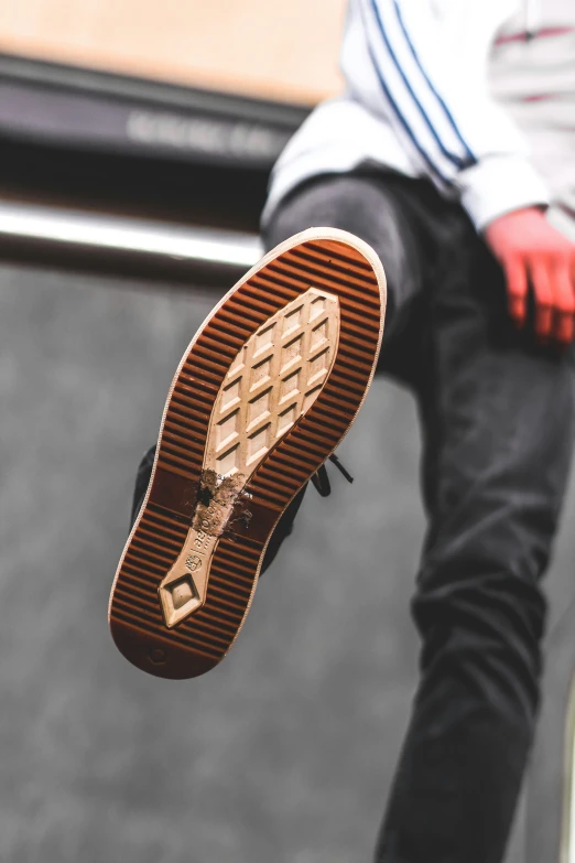 a person in white shirt sitting on ledge holding a shoe