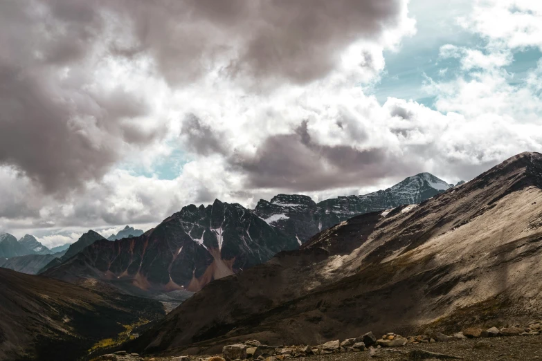 the mountains are covered with snow as clouds roll in