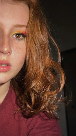 a young woman with yellow eyeshadow and brown hair