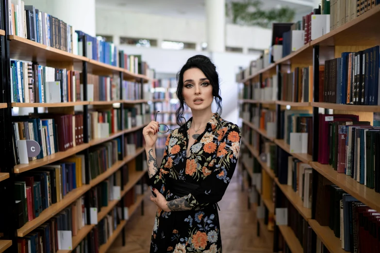 a woman standing next to shelves with many books on them