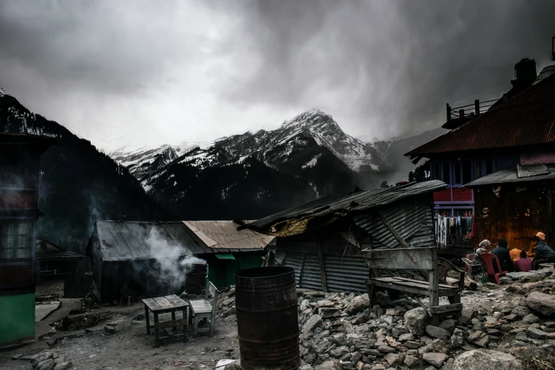 the storm clouds are passing over a small shack in a mountain town