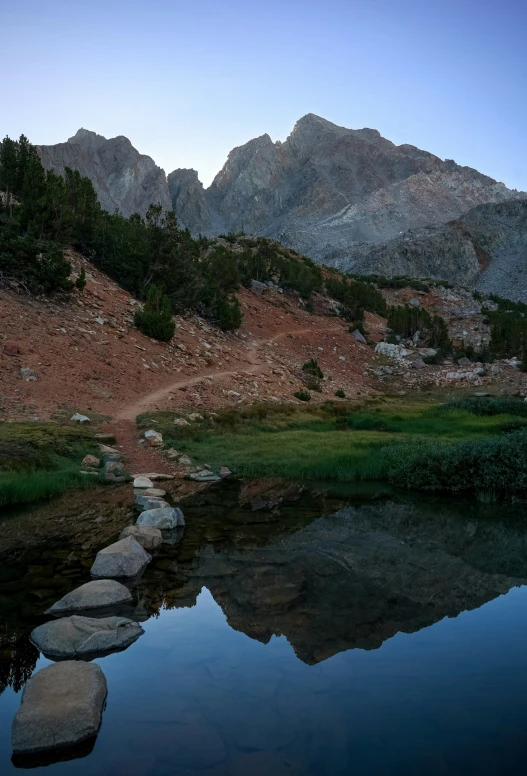 a trail near a pond is covered by stones