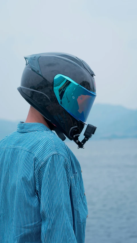 a person with a helmet on looking out into the water