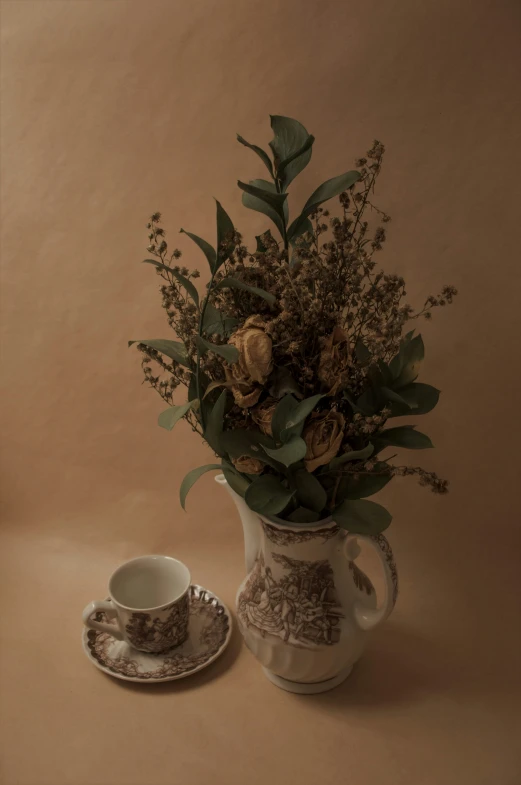 an old fashioned porcelain pitcher with a cup next to it