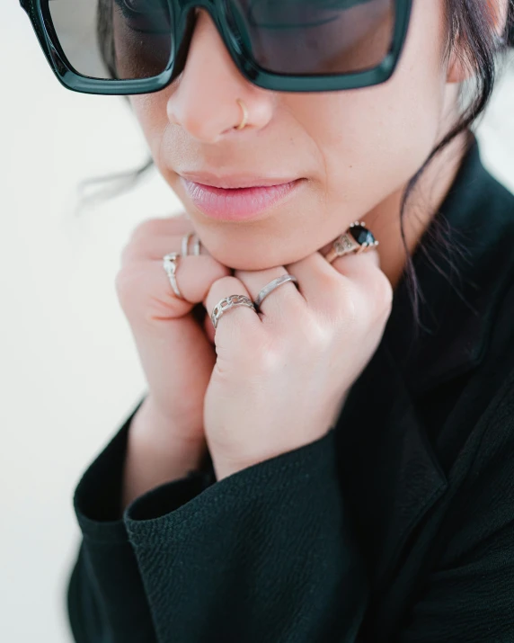 a woman wearing glasses and an ring with a black jacket