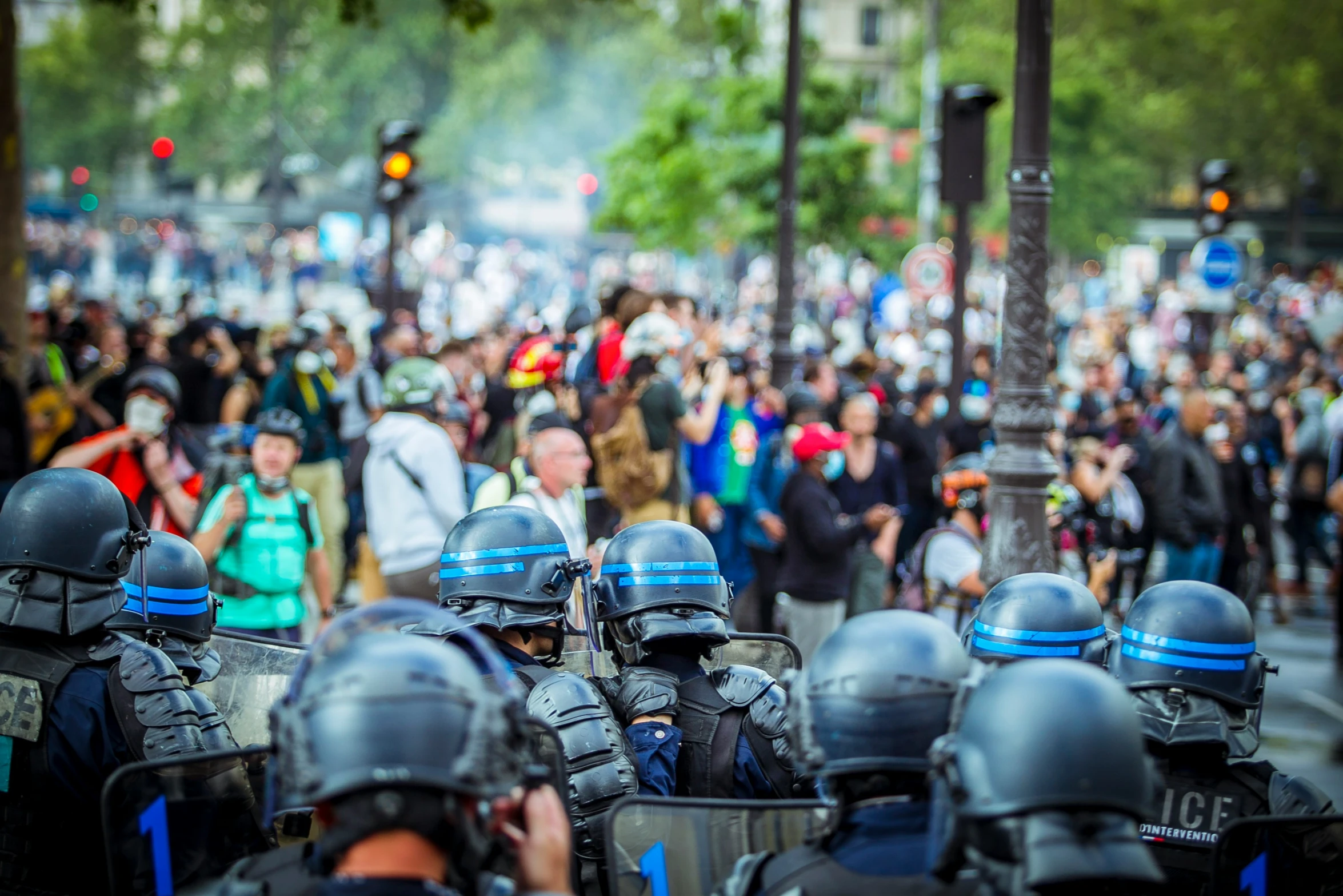 police officers marching down the street with people and traffic lights