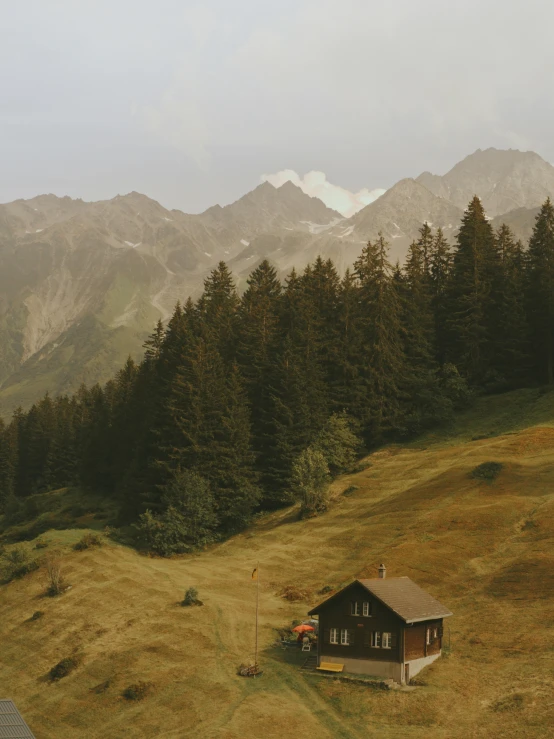 a cabin on the side of a hill in the mountains
