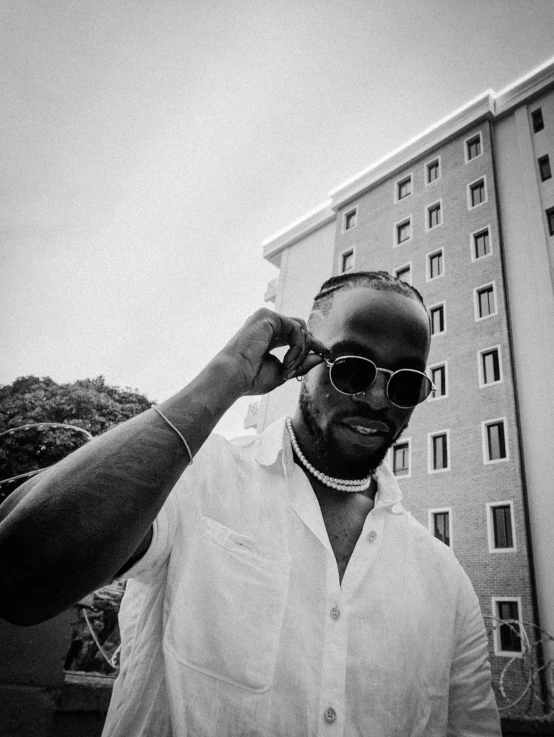 a man in glasses is walking outside near buildings