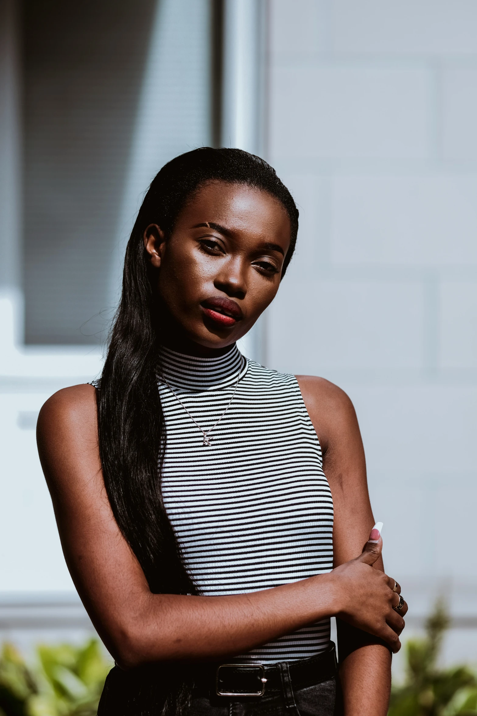 a woman posing for a pograph wearing a white and black striped shirt