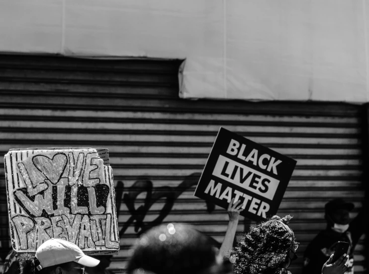 several people holding up protest signs with words and phrases