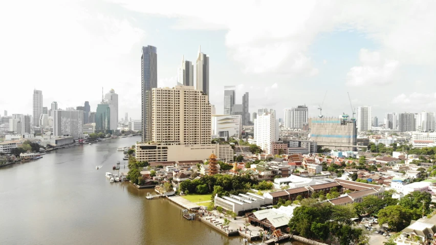 the aerial view of a river running between tall buildings in front of a city skyline