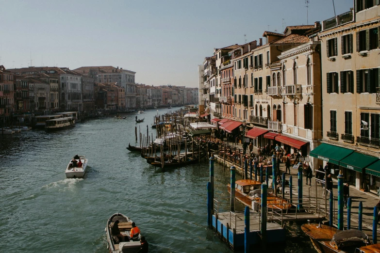 a long boat sailing down a river in front of buildings