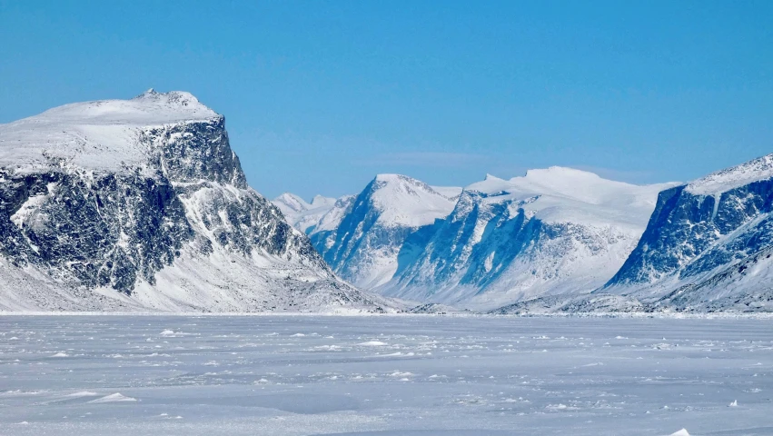 some mountains with white snow on top and a clear blue sky