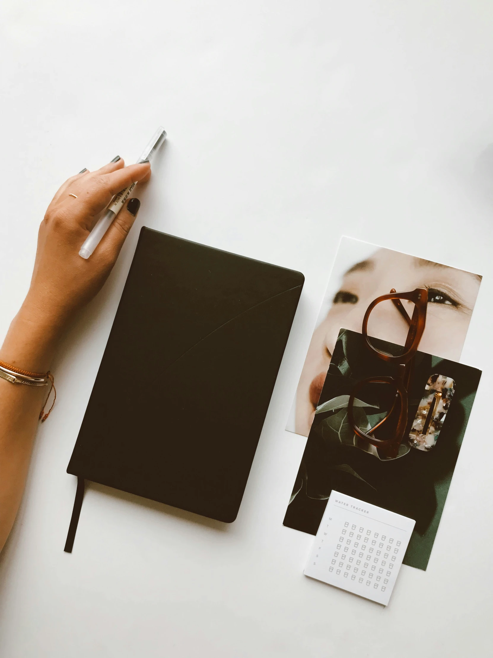 a picture of a woman is being held by a hand over a notebook with a picture of a person with a hand on it