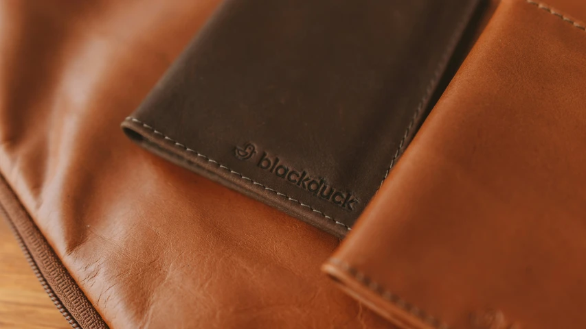 a wallet sits in the center of a brown leather bag