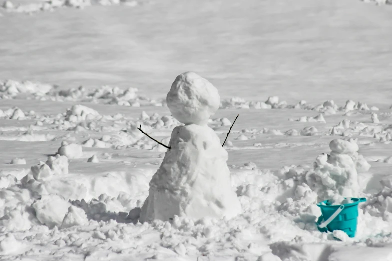 a snow man made with the tools of a shovel and a snow shovel