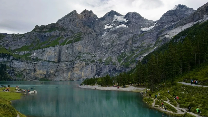 a lake that is surrounded by mountains on a cloudy day