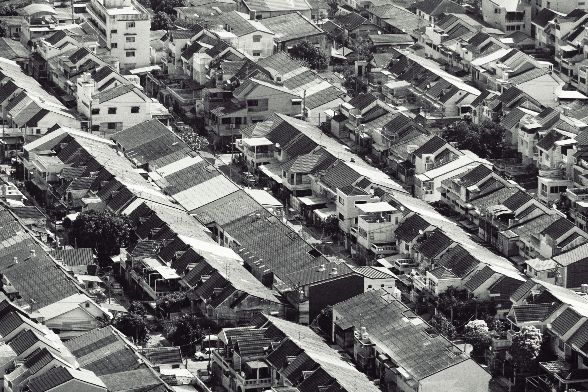 the black and white aerial view shows lots of roofs and buildings