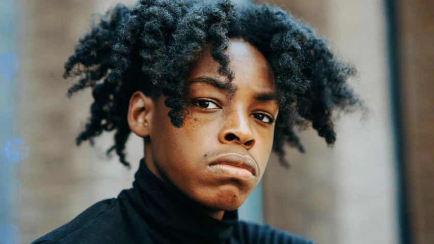 a young black man wearing a turtleneck sweater and tie