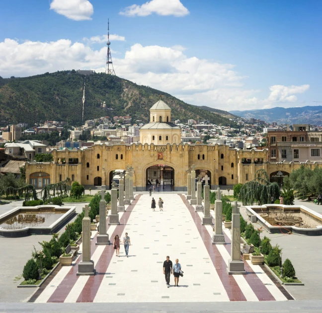 a view of a castle with some stairs and fountains in the front