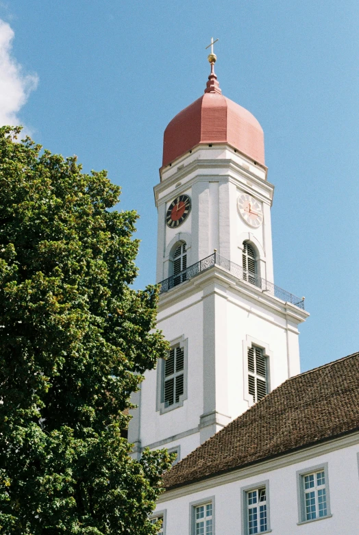 the front of an ornate white church with red dome