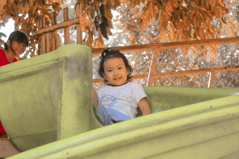 the girl is smiling and standing in the park