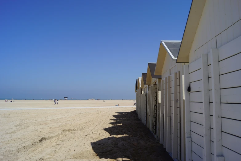 a row of beach huts on the sandy beach