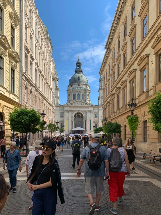 people are walking and sitting near buildings and a dome