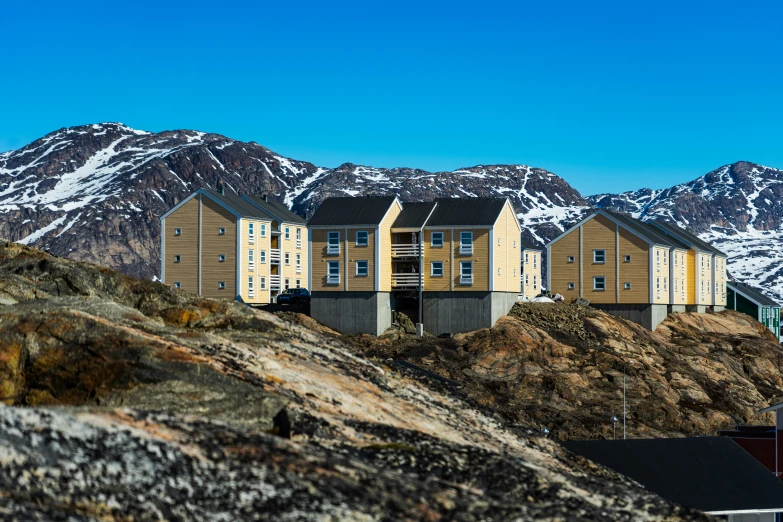 some houses sit on the hillside of an unpaved hill