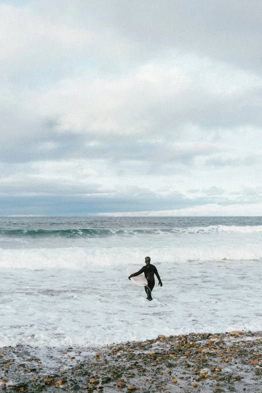 a man is holding his surfboard while running in the ocean