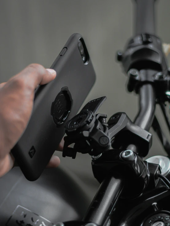 a person is fixing a motorcycle handle bar with the phone in their hand