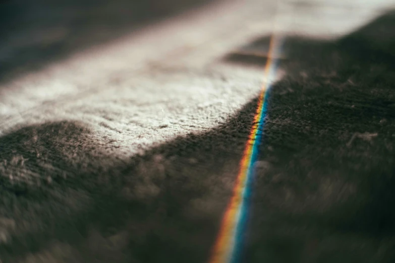 rainbow in the middle of the dark shadow of a wooden table