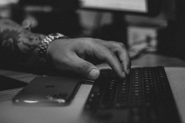 a person with one hand on a computer keyboard