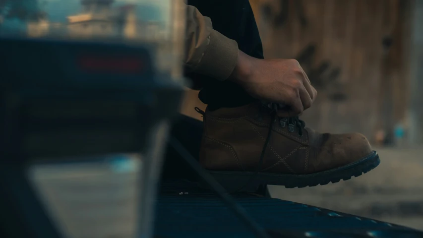 the shoes of a man in black jeans and brown boots