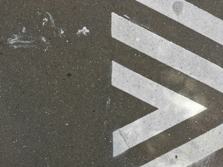 the arrow symbol is on the street near a cross walk