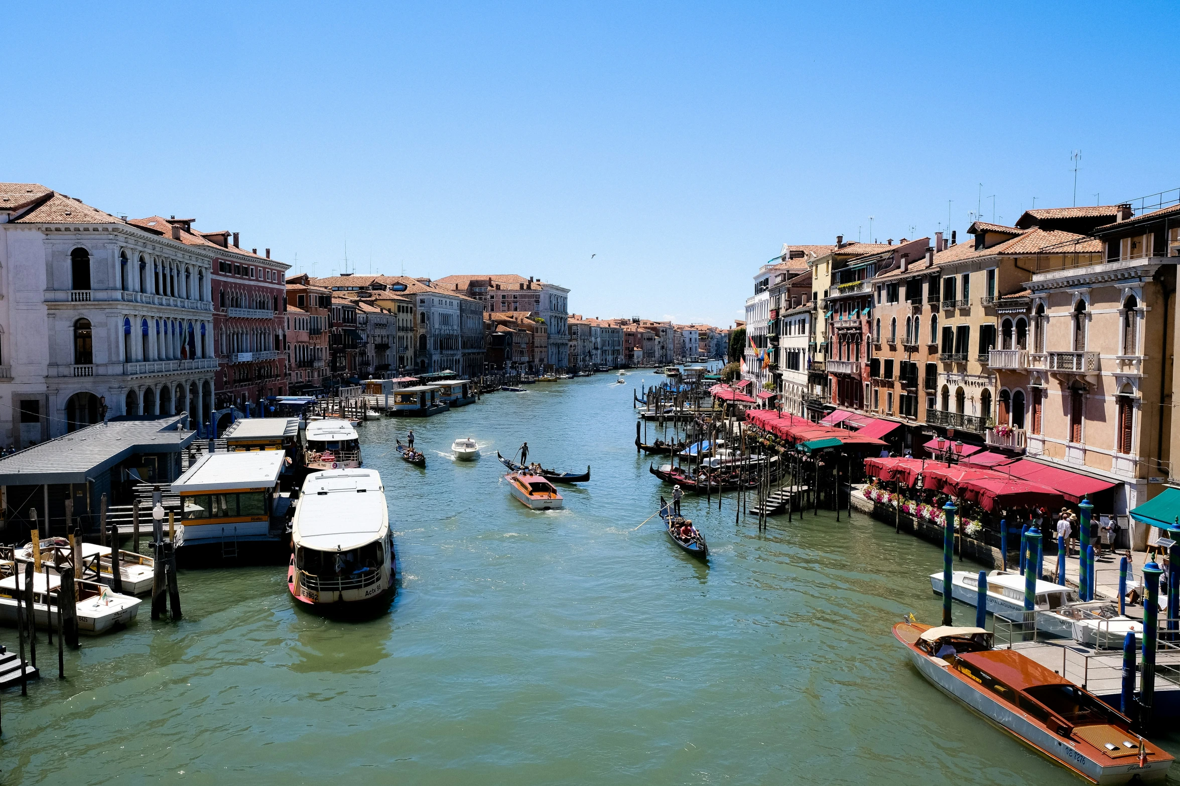 boats are parked along a canal with a bridge