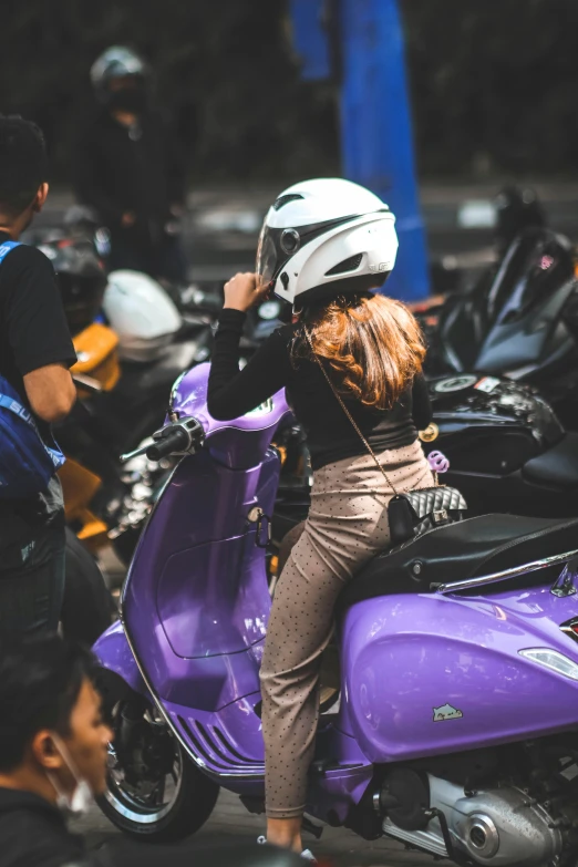 a woman in a helmet is on a scooter