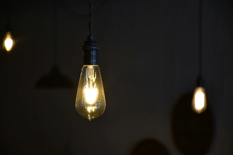 three light bulbs are hanging down from the ceiling