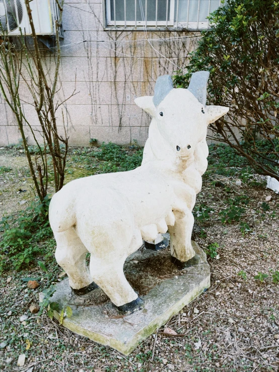 a statue of a goat in front of a building