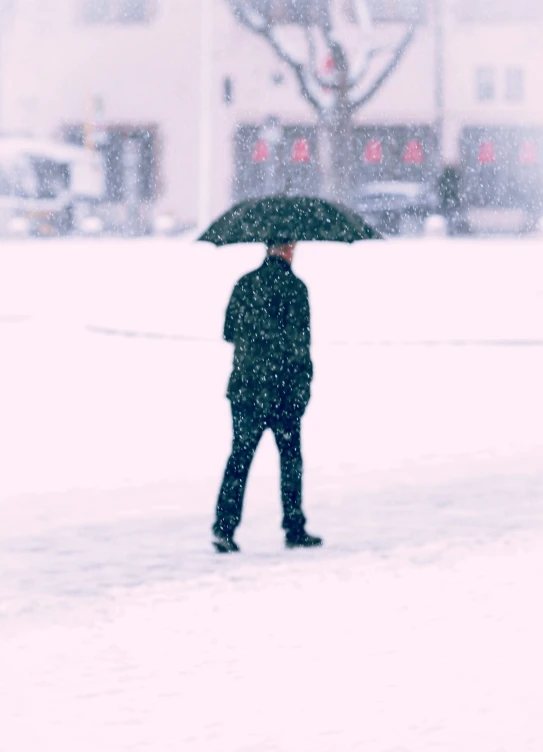 a man walking in the snow with an umbrella