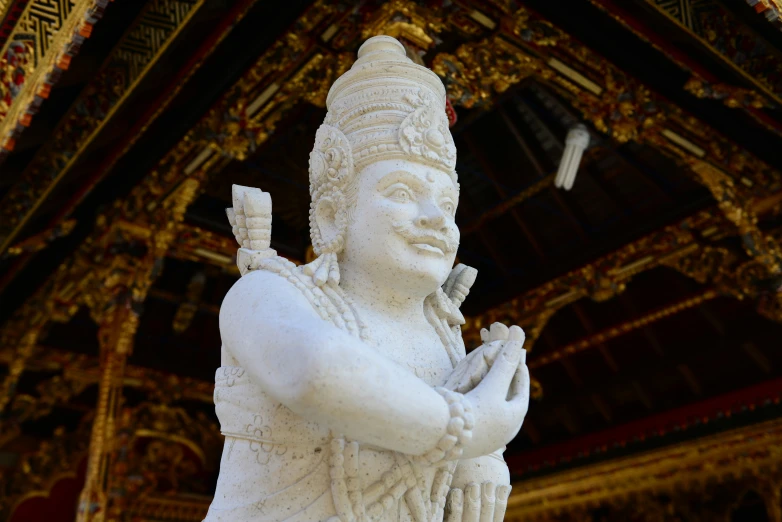 white statue of buddha holding his arms outstretched