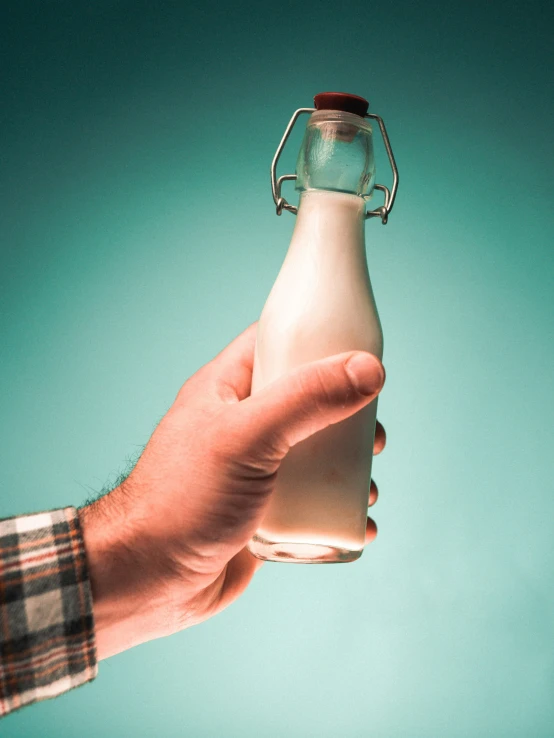 a person holding a bottle with no lid