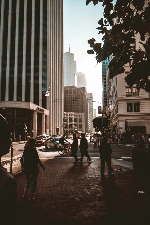 people walking down a road next to tall buildings