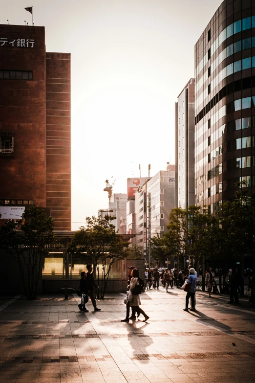 several people walk through the plaza in a city