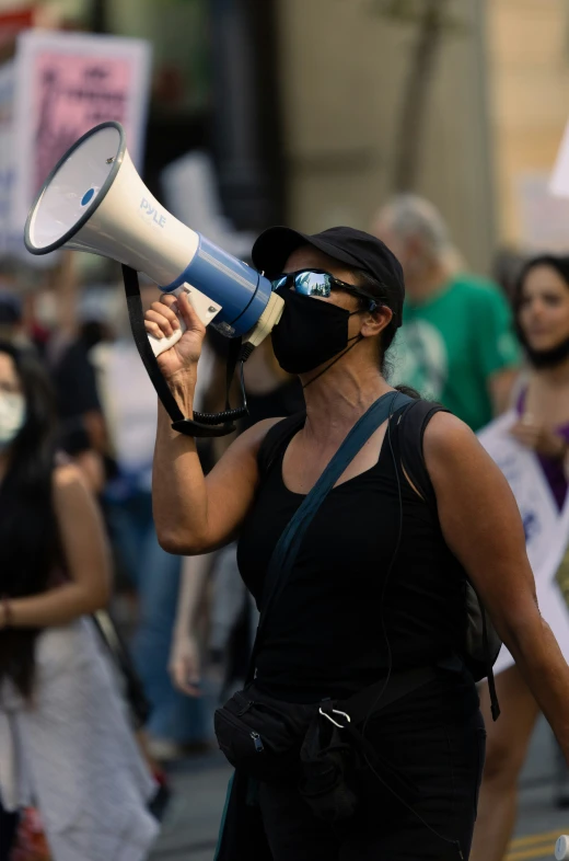 a woman with blind folded eyes is using a bullhorn