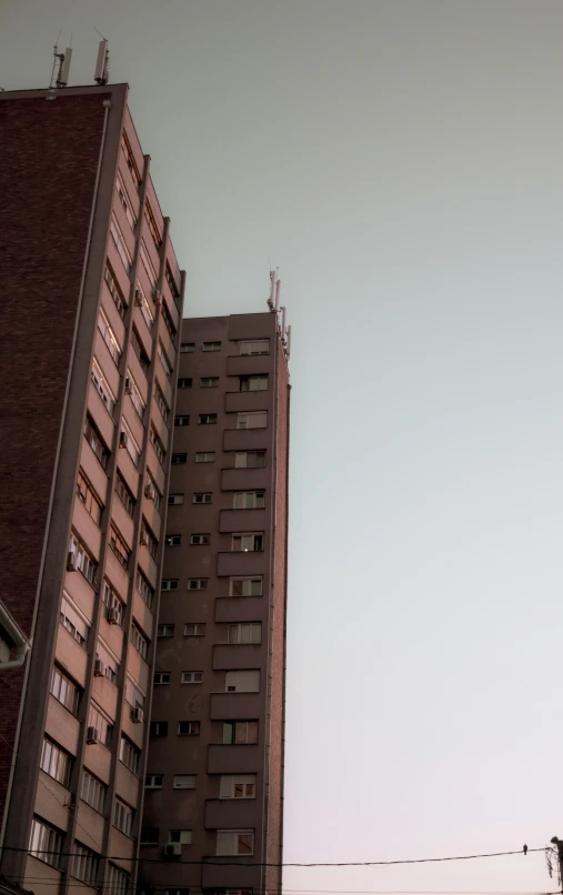 two large buildings next to each other against a clear sky