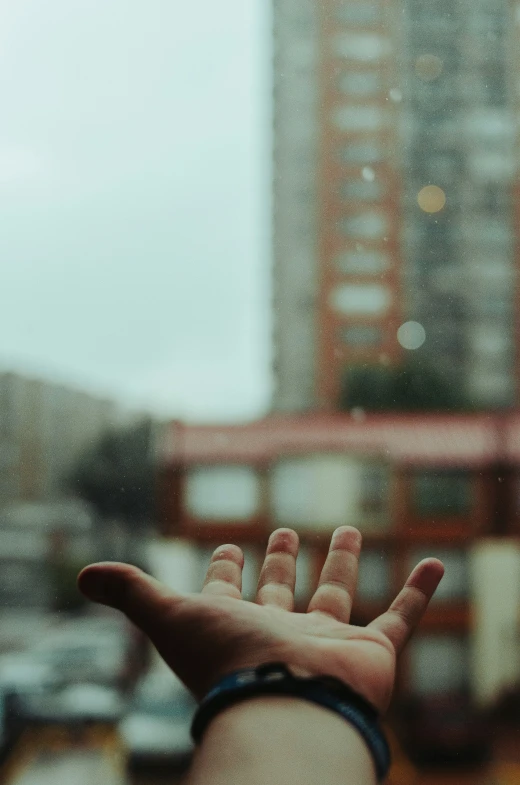 a hand is in front of a building