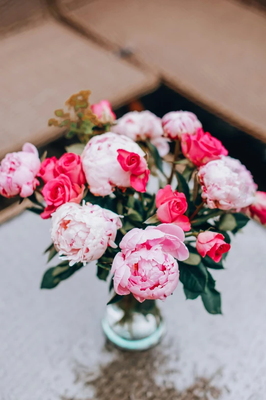 a glass vase filled with lots of pink and red flowers