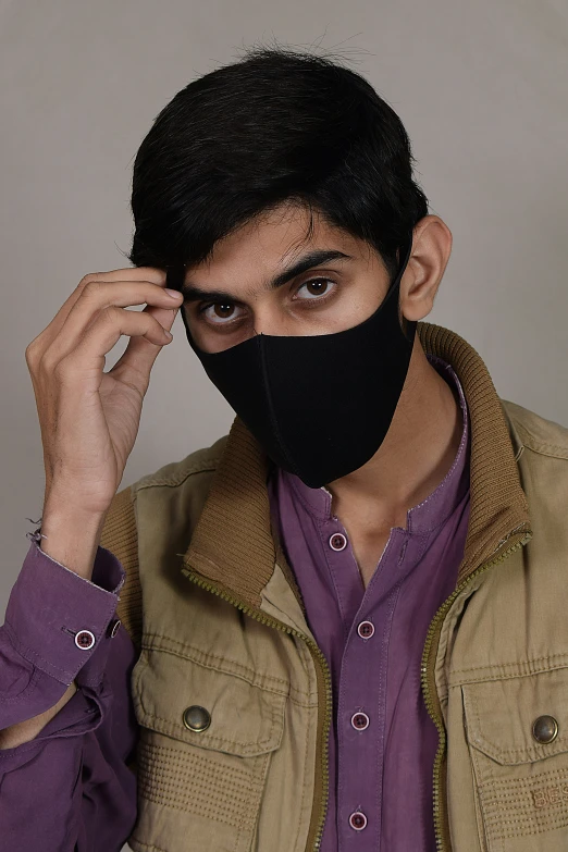 a young man wearing a black face mask