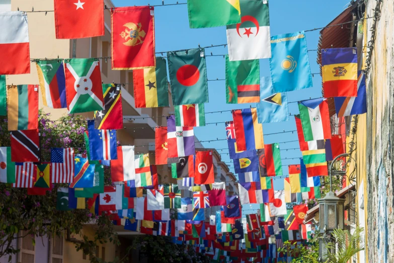 a long row of flags hanging on a fence